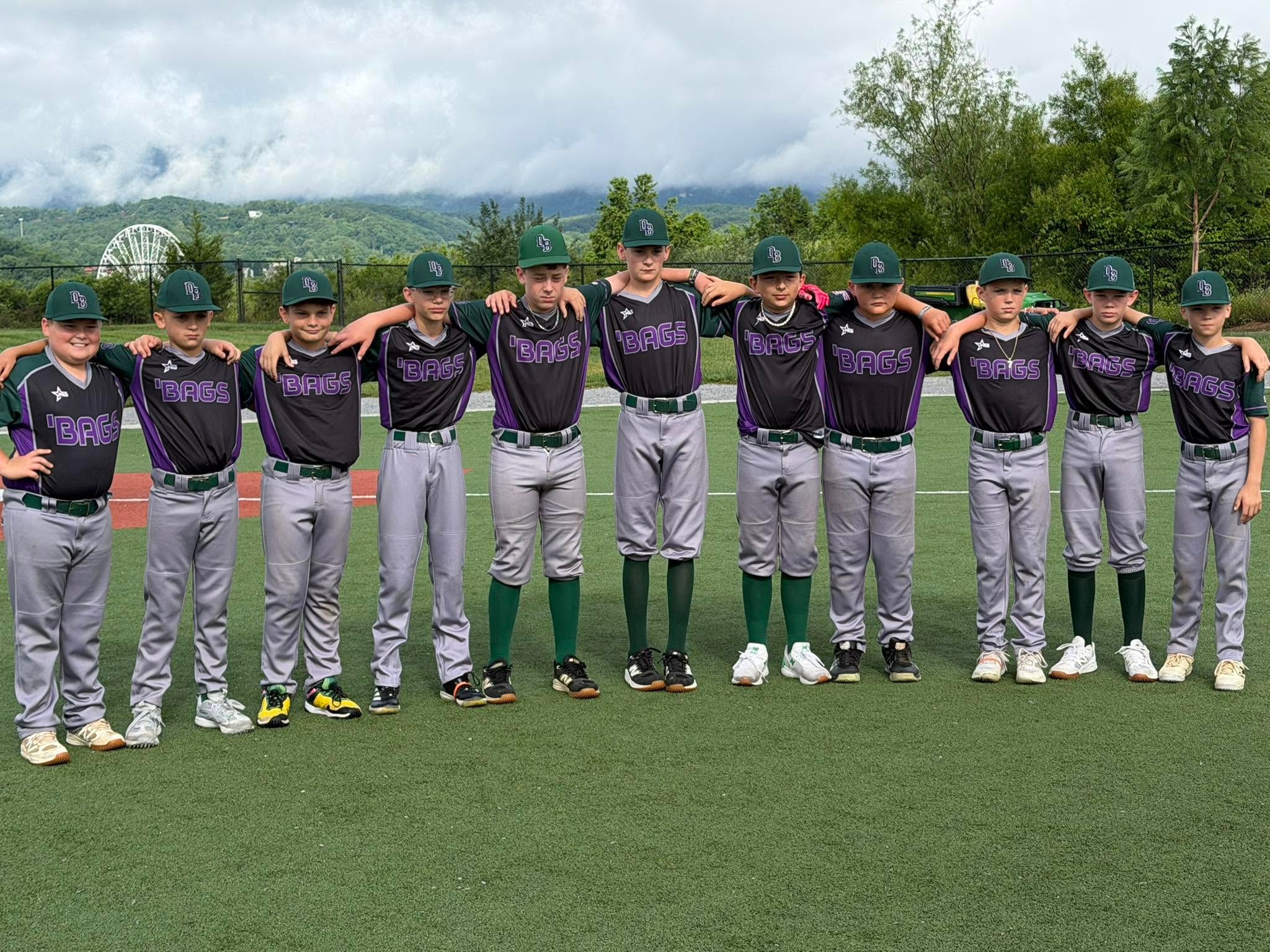 Dirtbags players in black and purple jerseys arm in arm on the field with mountains in the background